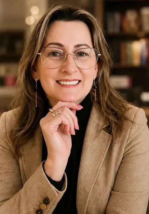 Cecília Hohenberger sorrindo, com a mão apoiada no queixo